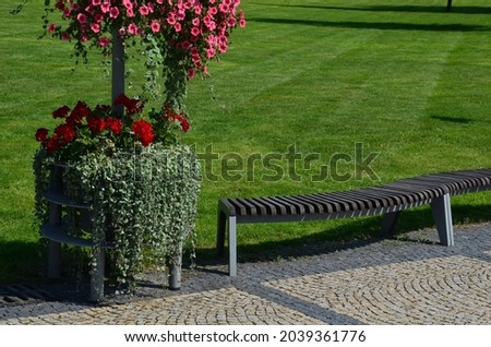 design bench in the shape of a wavy line. wooden paneling on a metal galvanized frame. The bench is atypical to order in a city park for young people and unusual sitting and lying