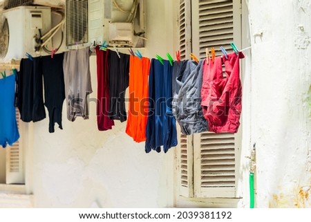 Clean, washed clothes are dried on a rope with clothespins in the outdoors