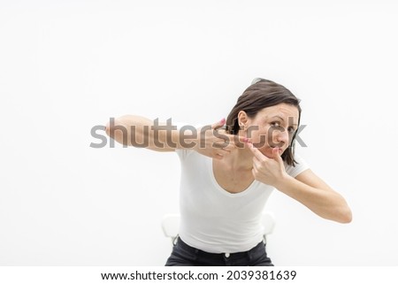 Photo of woman with acne problem squeezing pimple indoors.
