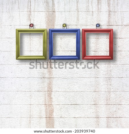 Multicolored  wooden frames for pictures on old stone wall