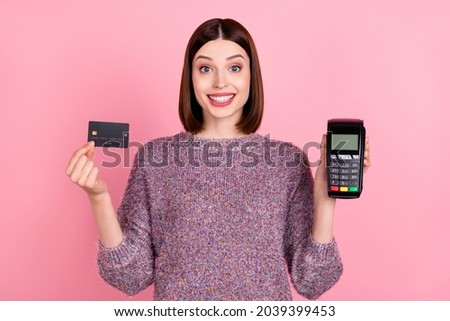 Photo of cheerful lady presenting debit card terminal reader wear knitted pullover isolated pink color background