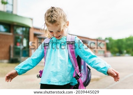 A girl with backpack is ready for her first day of school. Royalty-Free Stock Photo #2039445029