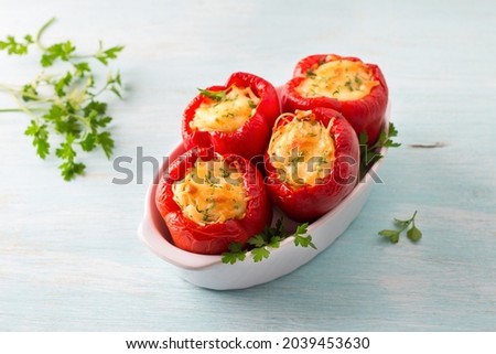 Bell red peppers stuffed with pasta, vegetables, cheese and herbs in baking dish on a light blue background, top view. Delicious homemade food Royalty-Free Stock Photo #2039453630