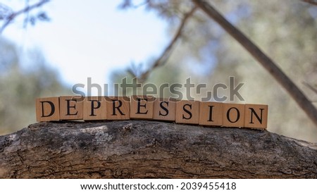 The word Depression was created from wooden cubes. Taken outside on a tree branch. close up