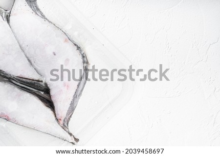 Halibut iced fillet plastic pack set, on white stone table background, top view flat lay, with copy space for text
