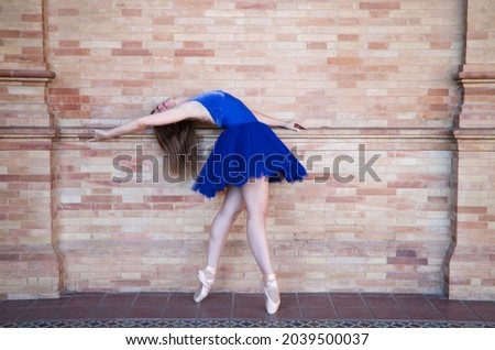 classical ballet dancer with turkey blue tutu doing different poses and postures on a background of red bricks. Classical ballet concept.