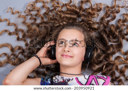 girl with beautiful hair lies in the headphones