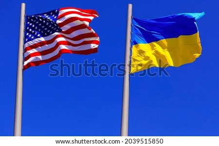 flags of the USA and Ukraine against bright blue sky