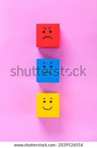 Red, blue and yellow cubes with cute faces depicting human emotions: anger, sadness and happiness. Concepts of mood swings, diversity of feelings and customer experience ratings Royalty-Free Stock Photo #2039526056