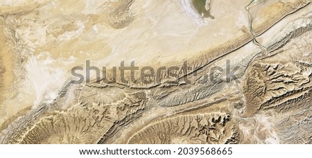 Aerial top view of sand terrain, desert land in satellite photo, topography, Earth surface map. Relief pattern background, landscape and topography theme. Elements of this image furnished by NASA Royalty-Free Stock Photo #2039568665