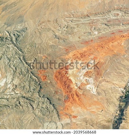 Desert land on satellite photo, aerial top view of Earth surface, physical map as abstract texture background. Nature pattern, terrain and topography theme. Elements of this image furnished by NASA.  Royalty-Free Stock Photo #2039568668