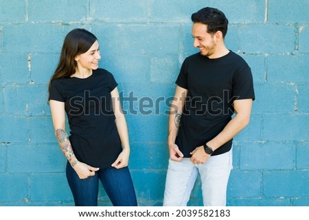 Matching t shirts. Young couple feeling happy after they had t-shirts made with the same designs Royalty-Free Stock Photo #2039582183