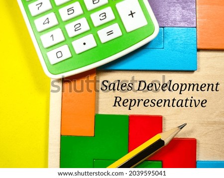 Business Concept.Text Sales Development Representative writing on wooden puzzle with calculator and pencil on yellow background.