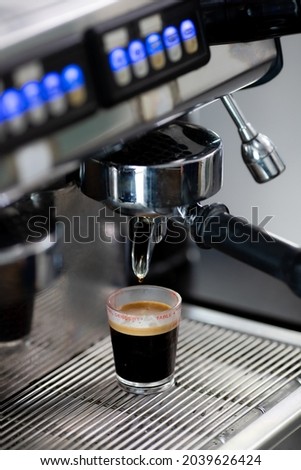 Close up photo of making coffee with machine in cafe. Professional modern espresso coffee machine pours hot drink into the cup. Concept coffee in cafe