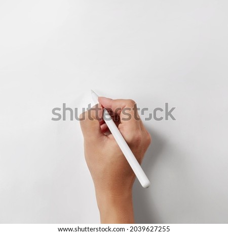 Hand holding a white stylus pen isolated on white background Royalty-Free Stock Photo #2039627255