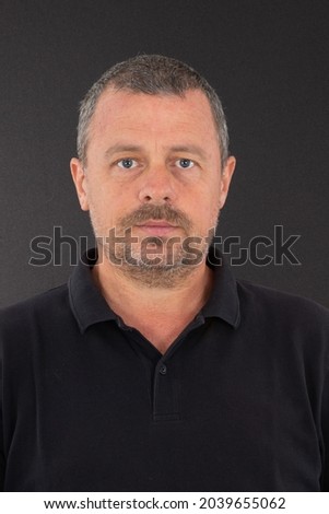 Man handsome in black shirt smiling portrait like id passport picture on grey Background