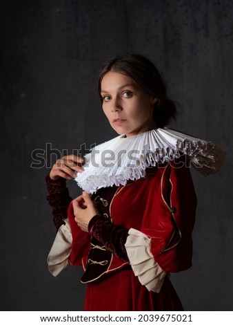 A noble lady in a luxurious red dress, medieval style, a young woman in a round Spanish collar, a portrait in the style of Renaissance paintings Royalty-Free Stock Photo #2039675021