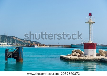 Lighthouse on ocean coastline over sky  and ship 