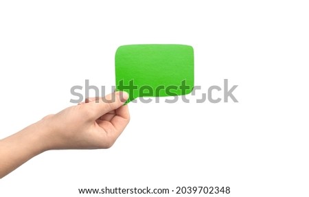 Green speech bubble in hand isolated on a white background. Giving feedback, communication concept photo. Empty cardboard text box mockup