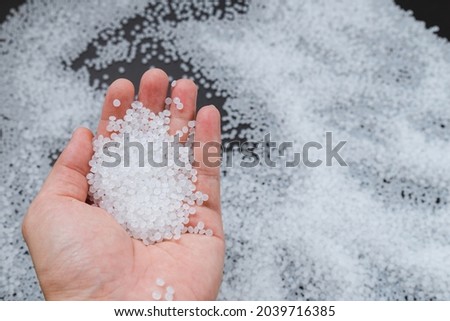 White plastic beads on wood  background, Polymers bead or polymer resin, polymer pallet, Product from petrochemical plants. granules polymer, Royalty-Free Stock Photo #2039716385