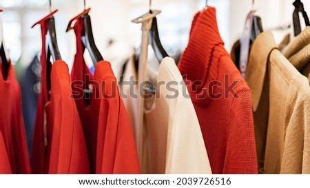 WEB banner format. Fashionable stylish women's clothing on a hanger. Knitted dresses and jumpers. Branded clothing in a show room. Fashion retail, show room, shopping or seasonal sale. Selective focus