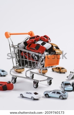 Right-view colorful toy cars in the shopping cart and on the floor on white background.
