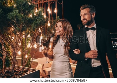 Beautiful young couple in formalwear spending time on night party Royalty-Free Stock Photo #2039784587