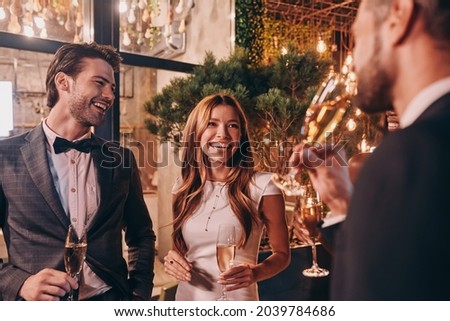 Group of people in formalwear communicating and smiling while spending time on luxury party Royalty-Free Stock Photo #2039784686