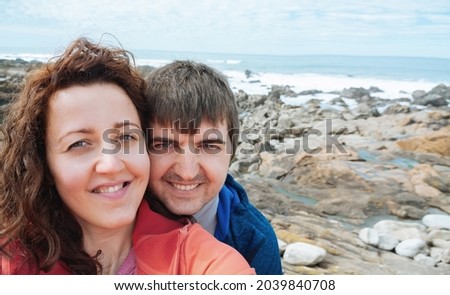Selfie of a young attractive tourist couple near the ocean promenade.
