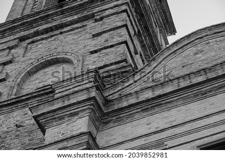 Partial view of the facade of an ancient medieval church in the village of Monterubbiano (Marche), black and white photo.