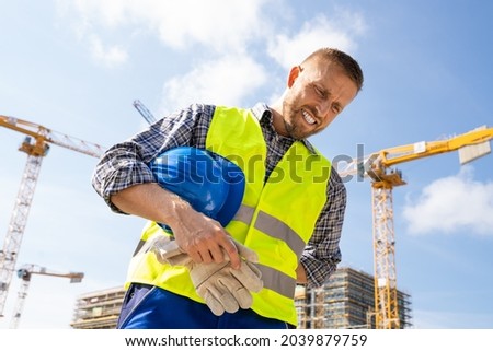 Engineer With Back Pain Injury After Accident At Construction Site Royalty-Free Stock Photo #2039879759