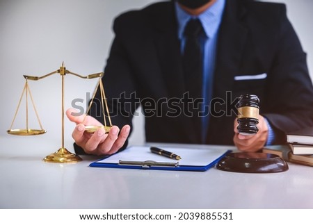 Judgment hammer on a wooden table and a male lawyer or judge works with courtroom style agreements. concept of justice and law