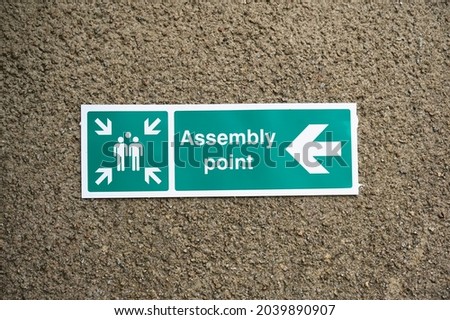 Fire assembly point sign at workplace signpost
