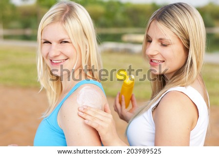 Woman applies sun lotion