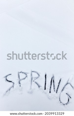 snow with drawings of the word spring in the winter season, the words spring drawn on the snow