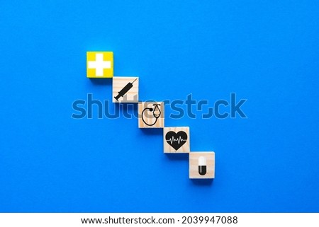 The notion of health insurance, Copy space on a blue wooden cube with healthcare medical symbols on a blue backdrop.