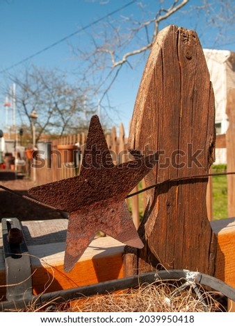
rusted metal star on fence post