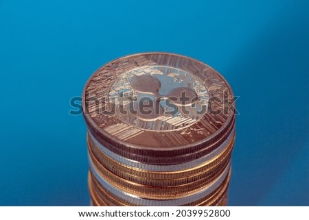 Stack of ripple coins over blue background