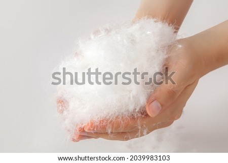 lots of white goose down feathers hold in both hands. Royalty-Free Stock Photo #2039983103