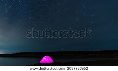 Beautiful night landscape The colorful star trails on the sky. Night time lapse photography.