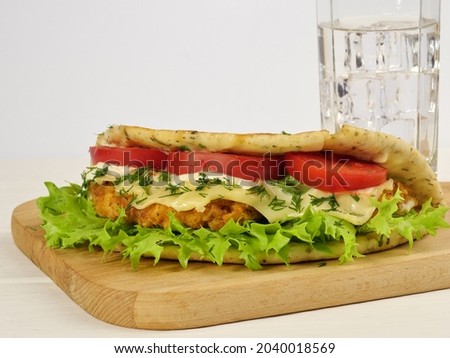 Panini Tuscany close-up. On a wooden board and a glass of ice water. On a white background. Proper nutrition. Close-up. Space for the text.