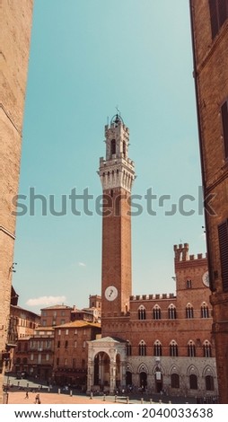 Clock tower in Siena Tuscany Italy. Shot between buildings. Frame within a frame.