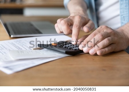 Close up on table lie document, invoices, receipts, utility bills, unrecognizable Caucasian male hands costs personal incomes and expenses using calculator, pay for loan, manage family budget concept Royalty-Free Stock Photo #2040050831