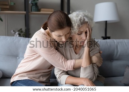Worried stressed young woman cuddling depressed emotional unhappy middle aged old retired mother, asking forgiveness or supporting in difficult life situation, comforting or soothing at home. Royalty-Free Stock Photo #2040051065