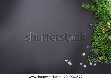 Layout on the theme of the New 2022 with toys and branches of a Christmas tree on a dark background.