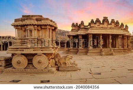 Medieval stone chariot with archaeological ruins in the courtyard of Vittala Temple at Hampi, Karnataka India at sunset Royalty-Free Stock Photo #2040084356