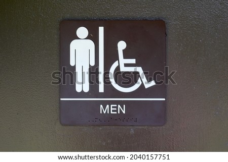 A close view of the men sign on the door in the pubic restroom.