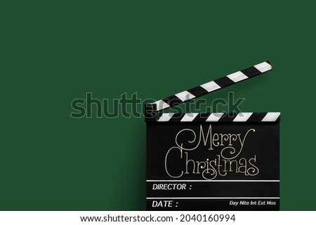 Merry Christmas, Handwriting on film slate.Green background.