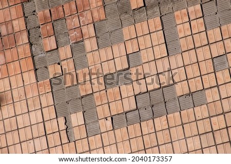 The texture of the old beige tiles resembling the shape of a brick