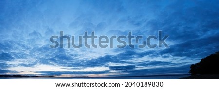 Panorama of Calm evening sky with clouds. Sky background after sunset. Sunrise sky with lighted clouds, Beauty evening sunrise over sea Royalty-Free Stock Photo #2040189830
